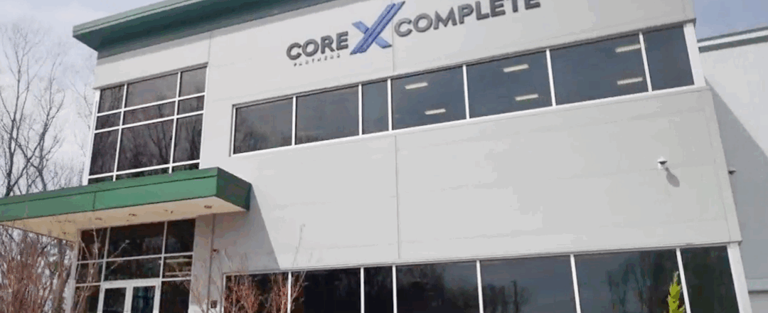 Core X Complete in New England front of building with green awning