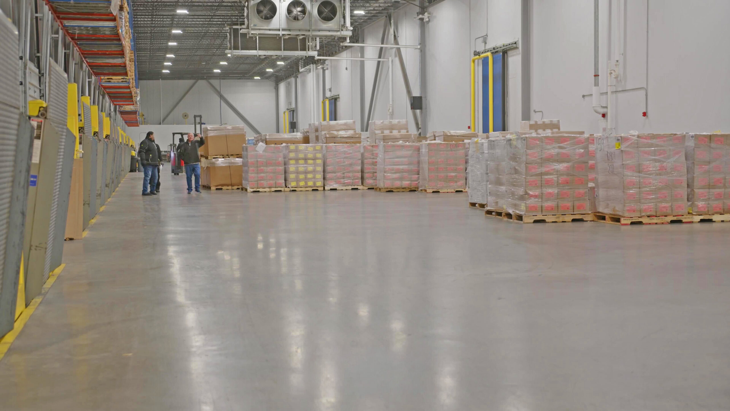 Team members at CORE X PREMIER walk among the pallets