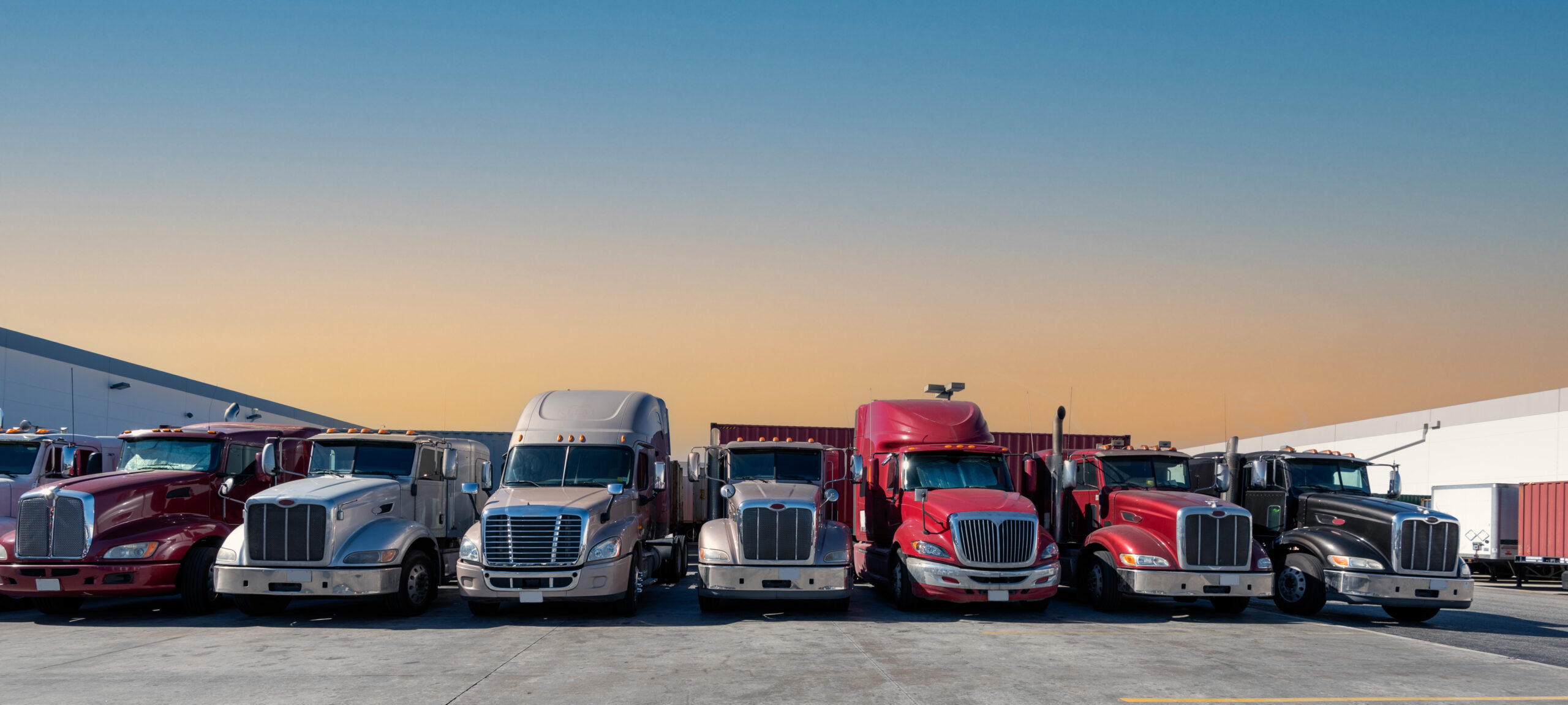 Lined up Semi truck heads on a parking lot at cold storage warehouse.